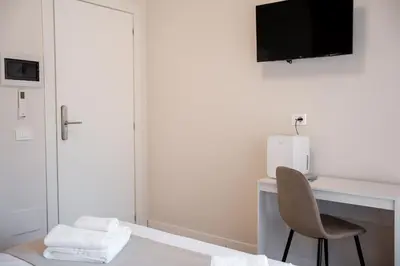 a room with a desk with a chair and a television at C&P Luxury Guest House Rome in Rome
