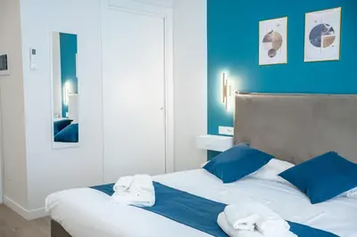 a bedroom with blue walls and a bed with blue pillows at C&P Luxury Guest House Rome in Rome