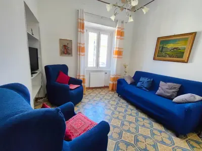 a living room with two blue couches and a television at Romein5minutes in Rome