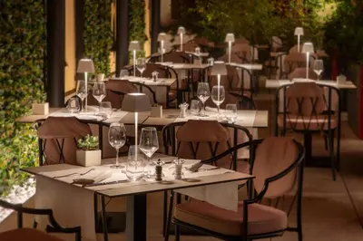 a row of tables with wine glasses on them at Rose Garden Palace Roma by OMNIA hotels in Rome