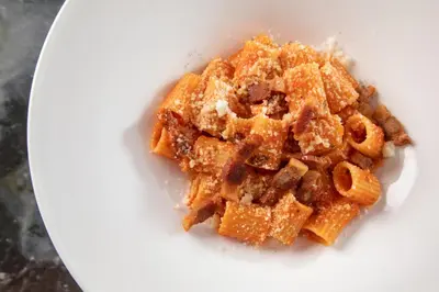 a white plate with a pile of food at Rose Garden Palace Roma by OMNIA hotels in Rome