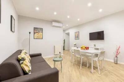 a living room with a couch and a table at Hostly-Suite Apartment Laterano-Walk to Colosseum in Rome