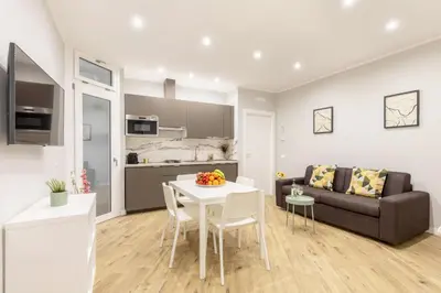a living room with a white table and a couch at Hostly-Suite Apartment Laterano-Walk to Colosseum in Rome