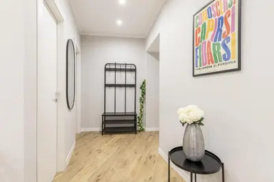 a hallway with a vase of flowers on a table at Hostly-Suite Apartment Laterano-Walk to Colosseum in Rome