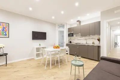 a kitchen and living room with a table and chairs at Hostly-Suite Apartment Laterano-Walk to Colosseum in Rome