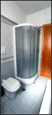 a bathroom with a toilet and a glass shower at Il Cupolone in Pineta - Two steps in the pinewood towards the Vatican! in Rome