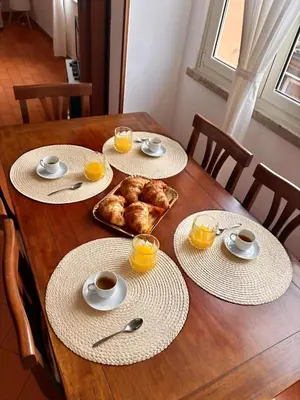 a wooden table with plates of food and orange juice at Ad Maiora Domus in Rome