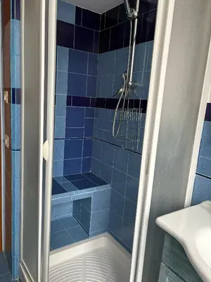 a blue tiled shower in a bathroom with a sink at Ad Maiora Domus in Rome