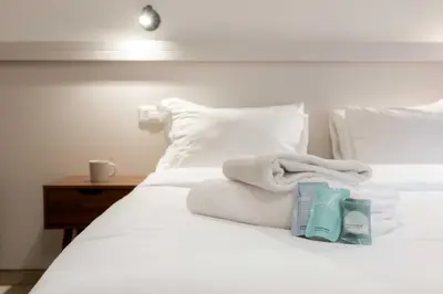 a bed with white sheets and towels on it at Renovated 2-bdr flat Statuto - ZEN 51 in Rome