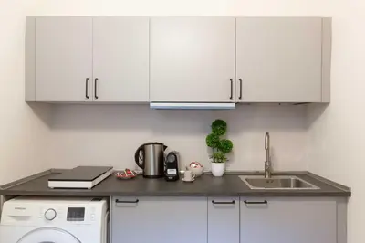 a kitchen with white cabinets and a sink at Renovated 2-bdr flat Statuto - ZEN 51 in Rome