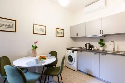 a kitchen with a table and a washing machine at Renovated 2-bdr flat Statuto - ZEN 51 in Rome