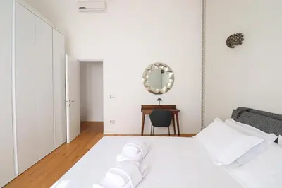a bedroom with a white bed and a mirror at Lux San Pietro Apartment in Rome