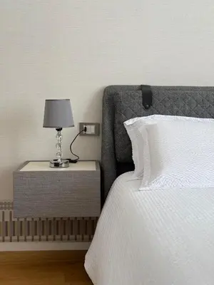 a bed with a side table with a lamp on it at Lux San Pietro Apartment in Rome