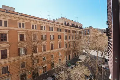 a large brick building with trees in front of it at Lux San Pietro Apartment in Rome