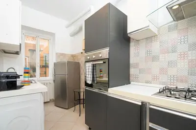 a kitchen with gray cabinets and a stove top oven at San Pietro Apartment 66 in Rome