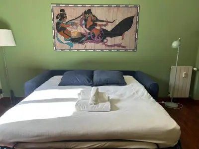 a bed in a room with a painting on the wall at Casa Nina Ostiense - Roma Tre - by GHOR in Rome