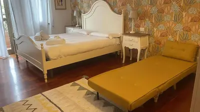a bedroom with two beds and a bench in it at Casa Nina Ostiense - Roma Tre - by GHOR in Rome