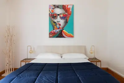 a bedroom with a bed and a painting of a woman with sunglasses at San Paolo Private Garden Home in Rome