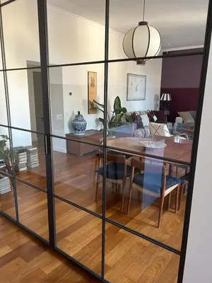 a dining room with a glass wall in a living room at Bright Apartment in San Lorenzo - Feel at Home in Rome