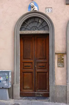 a wooden door of a building with a statue above it at old town Holy Door of Santa Maria Maggiore in Rome
