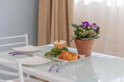 a table with a cake and a vase of flowers at Luxury Maison Dei Colli in Rome