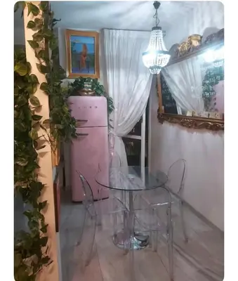 a dining room with a table and a pink refrigerator at Casa Serenissima Holiday Home Roma Barbara Bonanno in Rome