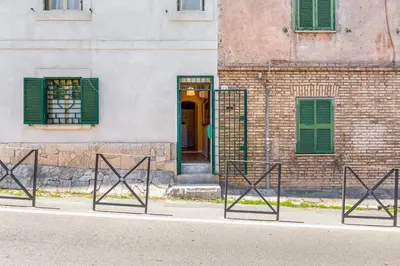 a building with green shutters and a door at BDC - The ancient Aqueduct in Rome
