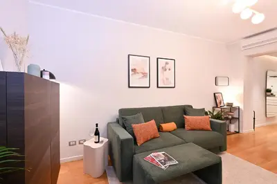 a living room with a green couch and orange pillows at Monti luxury patio apartment in Rome