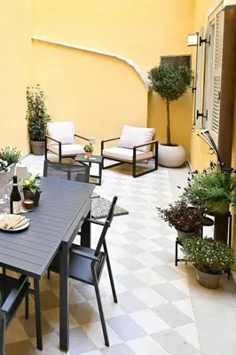 a patio with tables and chairs and potted plants at Monti luxury patio apartment in Rome