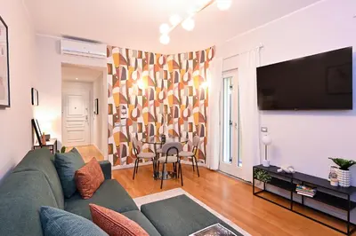 a living room with a couch and a table with chairs at Monti luxury patio apartment in Rome