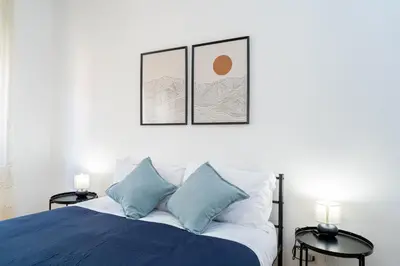 a bedroom with a bed with blue and white pillows at Domus Bonadies - Musei Vaticani - San Pietro in Rome