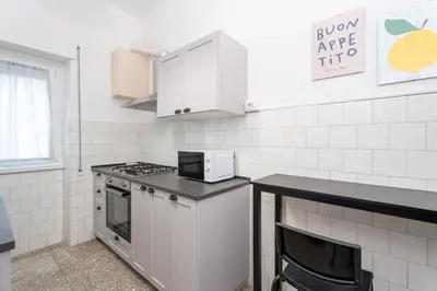 a white kitchen with a stove and a microwave at Domus Bonadies - Musei Vaticani - San Pietro in Rome