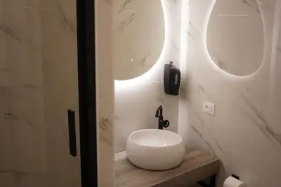 a bathroom with a white sink and two mirrors at Tito Livio Vatican Home in Rome
