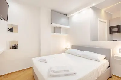 a white bedroom with a bed with towels on it at Tito Livio Vatican Home in Rome