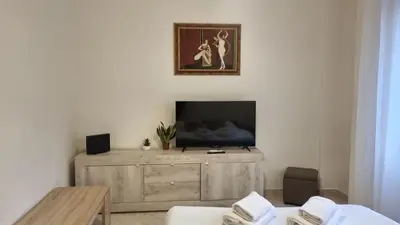 a living room with a television on a wooden dresser at At the Pope's bridge in Rome