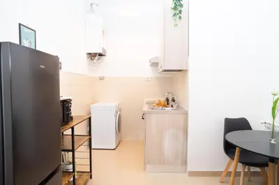 a small kitchen with a table and a refrigerator at Modern two-room apartment for 2, 20 minutes from Termini in Rome
