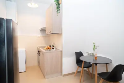 a small kitchen with a small table and a table and chairs at Modern two-room apartment for 2, 20 minutes from Termini in Rome