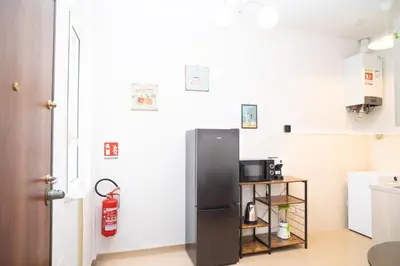a kitchen with a refrigerator and a small table at Modern two-room apartment for 2, 20 minutes from Termini in Rome