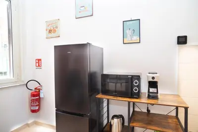 a kitchen with a refrigerator and a table with a microwave at Modern two-room apartment for 2, 20 minutes from Termini in Rome