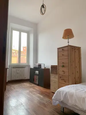 a bedroom with a bed and a dresser and a window at Milizie Vintage in Rome