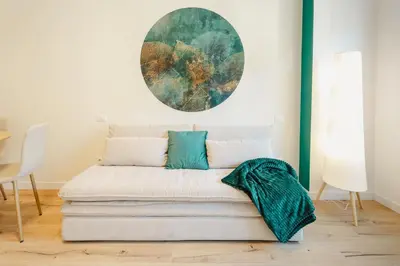 a couch in a room with a painting on the wall at Smeraldo Vatican Moments in Rome