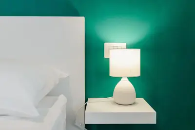 a white lamp sitting on a table next to a bed at Smeraldo Vatican Moments in Rome