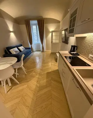 a kitchen and living room with a table and a couch at Residenza Vittorio Veneto in Rome