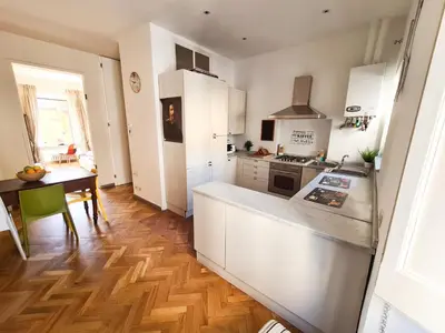 a kitchen with white cabinets and a wooden floor at Boutique Domus Charme Trastevere Vascellari in Rome