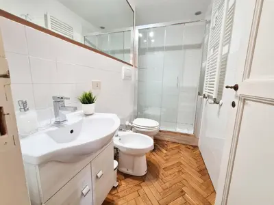 a white bathroom with a toilet and a sink at Boutique Domus Charme Trastevere Vascellari in Rome