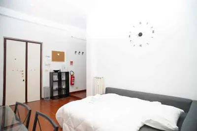 a white bedroom with a bed and a glass table at Modern and Central One-Bedroom, 10 min from Colosseum in Rome