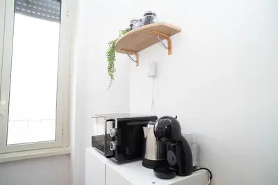 a coffee maker on a shelf in a kitchen at Modern and Central One-Bedroom, 10 min from Colosseum in Rome