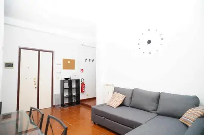 a living room with a couch and a glass table at Modern and Central One-Bedroom, 10 min from Colosseum in Rome