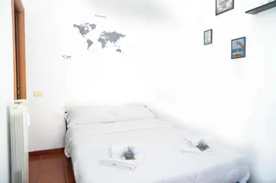 a bedroom with a white bed with a world map on the wall at Modern and Central One-Bedroom, 10 min from Colosseum in Rome