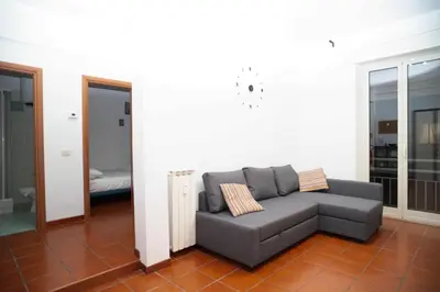 a living room with a gray couch in a room at Modern and Central One-Bedroom, 10 min from Colosseum in Rome